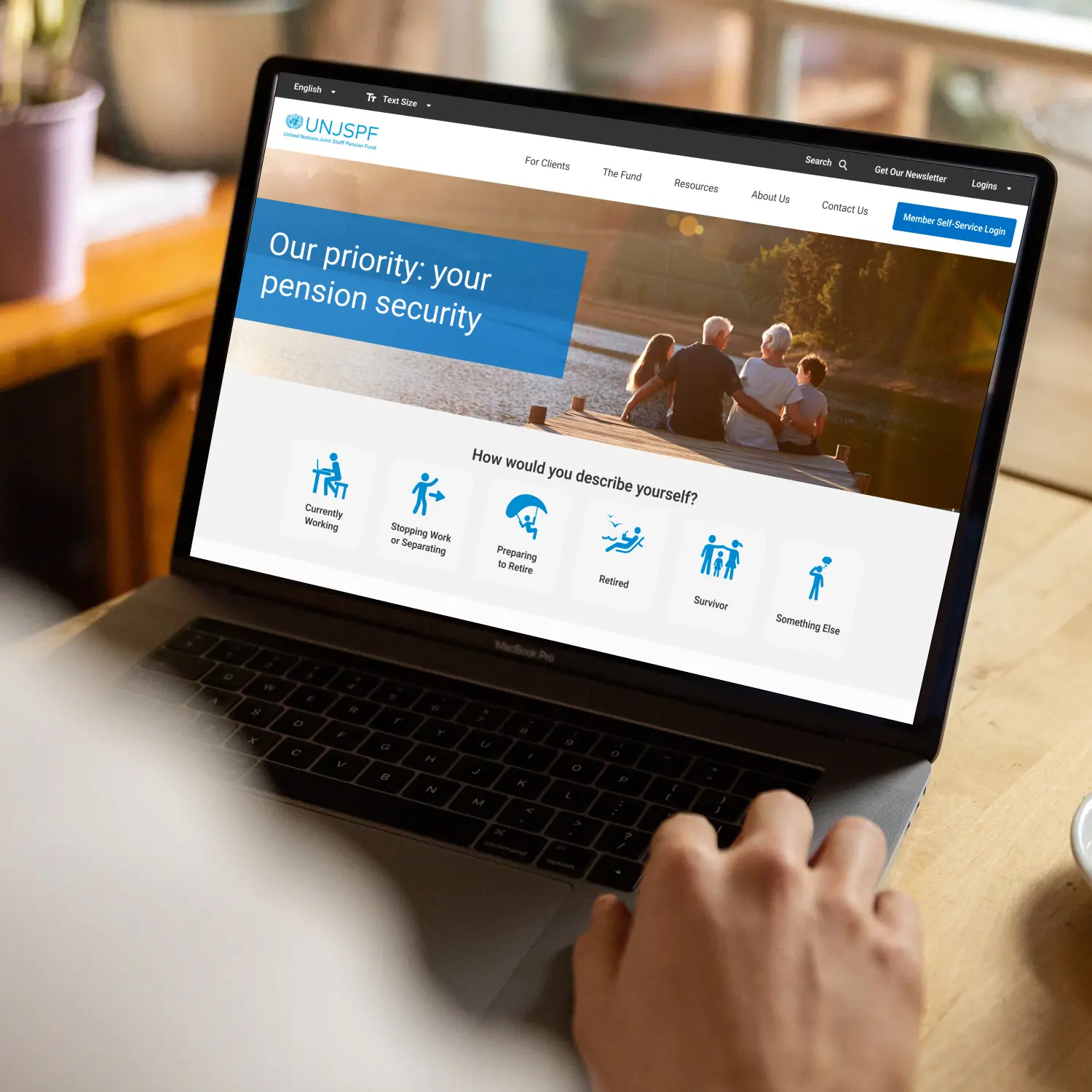 UNJSPF redesigned homepage displayed on a laptop, with the pension security banner and shortcuts for different life stages.